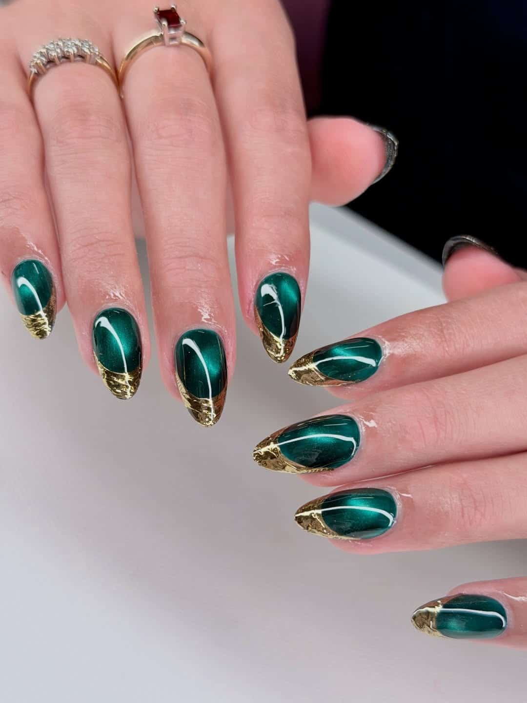 14. Emerald Green Cat Eye Nails with Gold Foil Tips - green and gold nail ideas