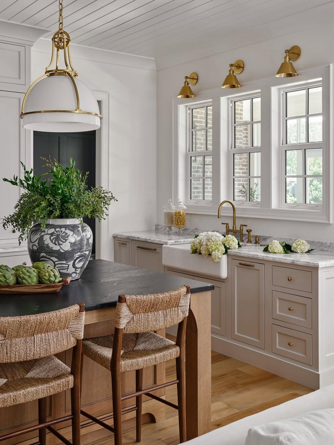 8. Soft Greige Kitchen with Black Island and Natural Woven Chairs - natural kitchen ideas