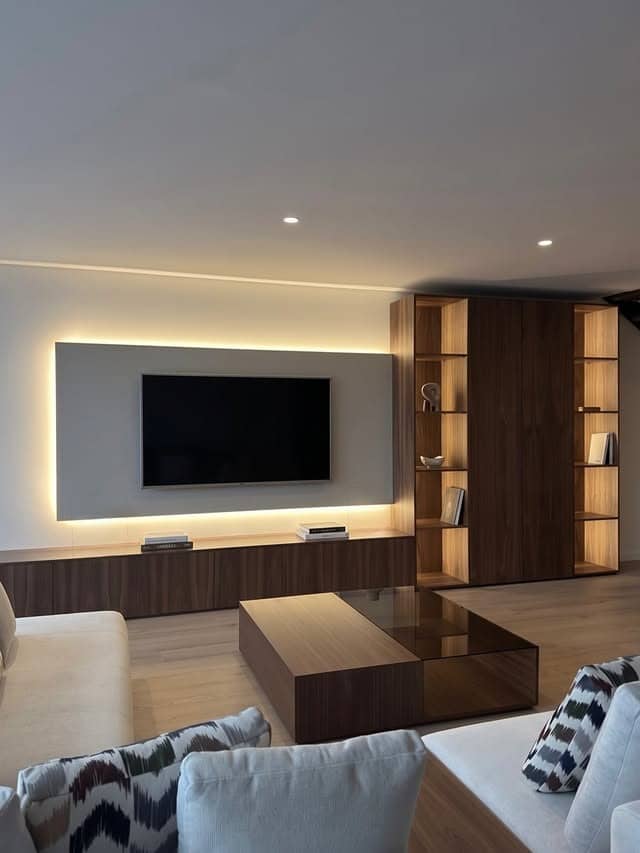 4. Minimalist Walnut Brown Entertainment Center with Backlit TV Panel - living room entertainment center ideas