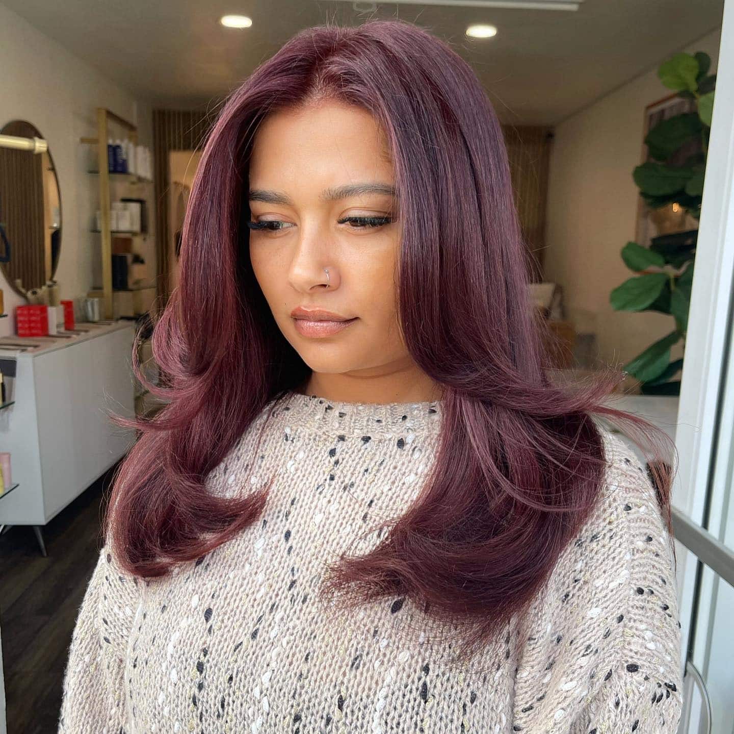 6. Muted Plum Red Hair with Voluminous Feathered Layers - Red Hair Color