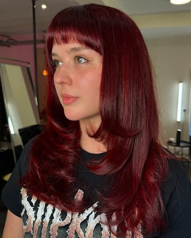 22. Deep Cherry Red Hair with Blunt Bangs and Feathered Layers - Red Hair Color