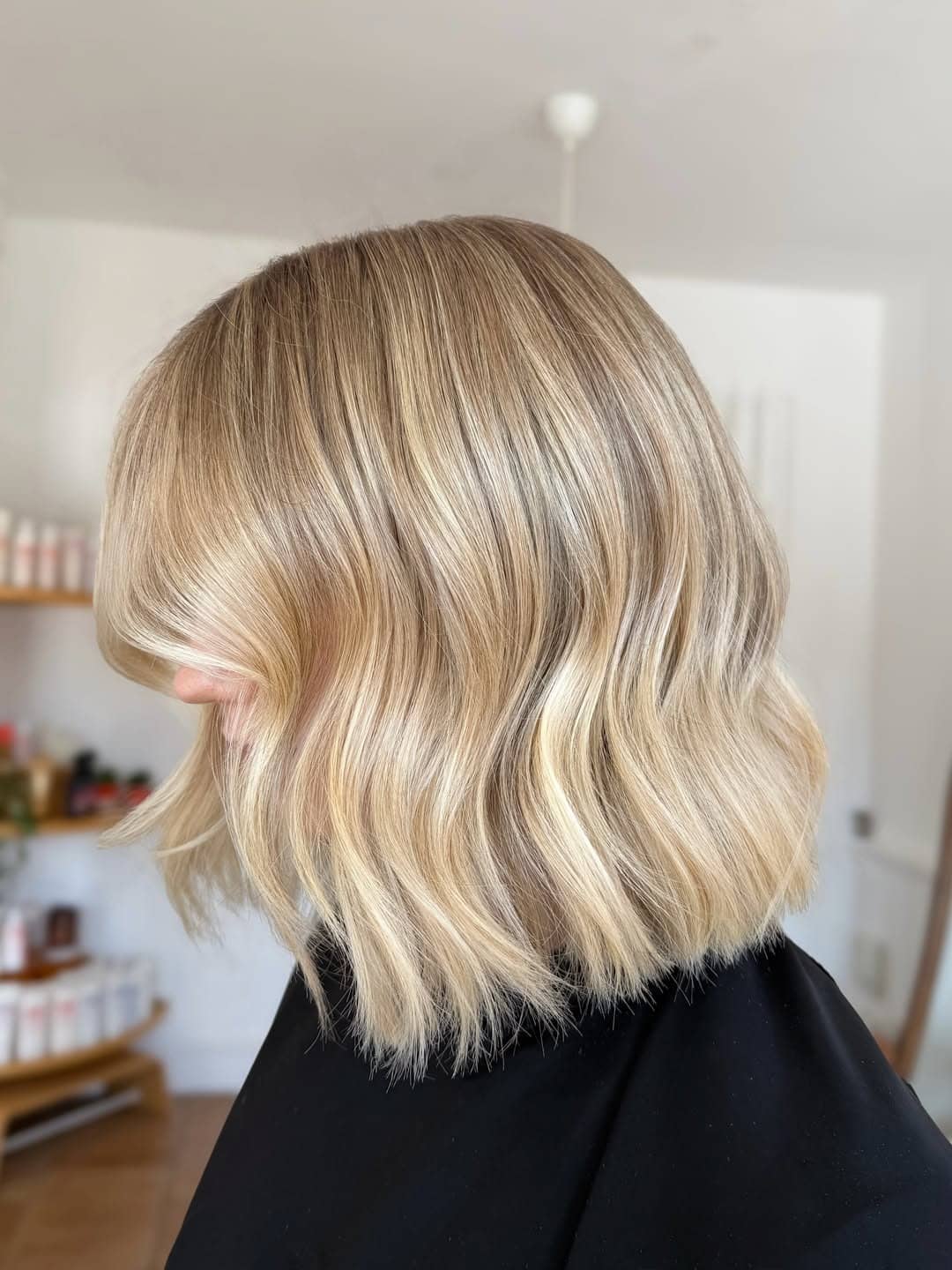 13. Buttery Beige Blonde Wavy Bob with Side-Swept Bangs - Short Blonde Hairstyles